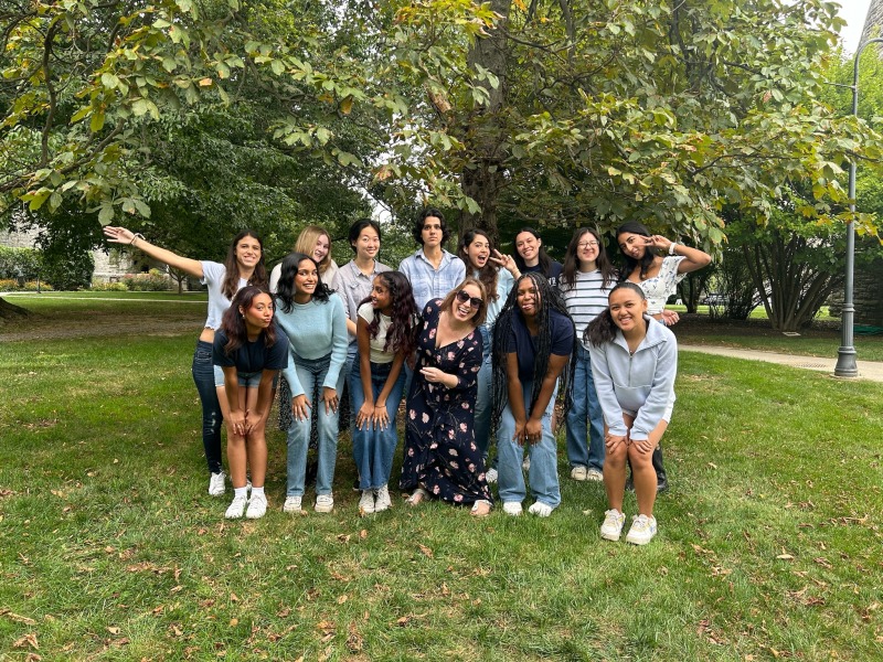 Group of people doing silly poses in front of a tree.