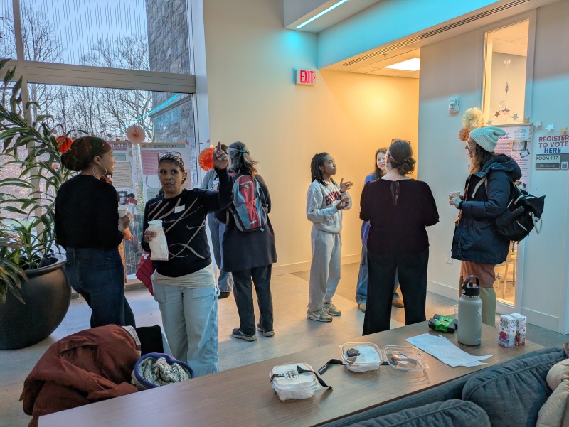 Students engaging with community members at the Praxis poster session