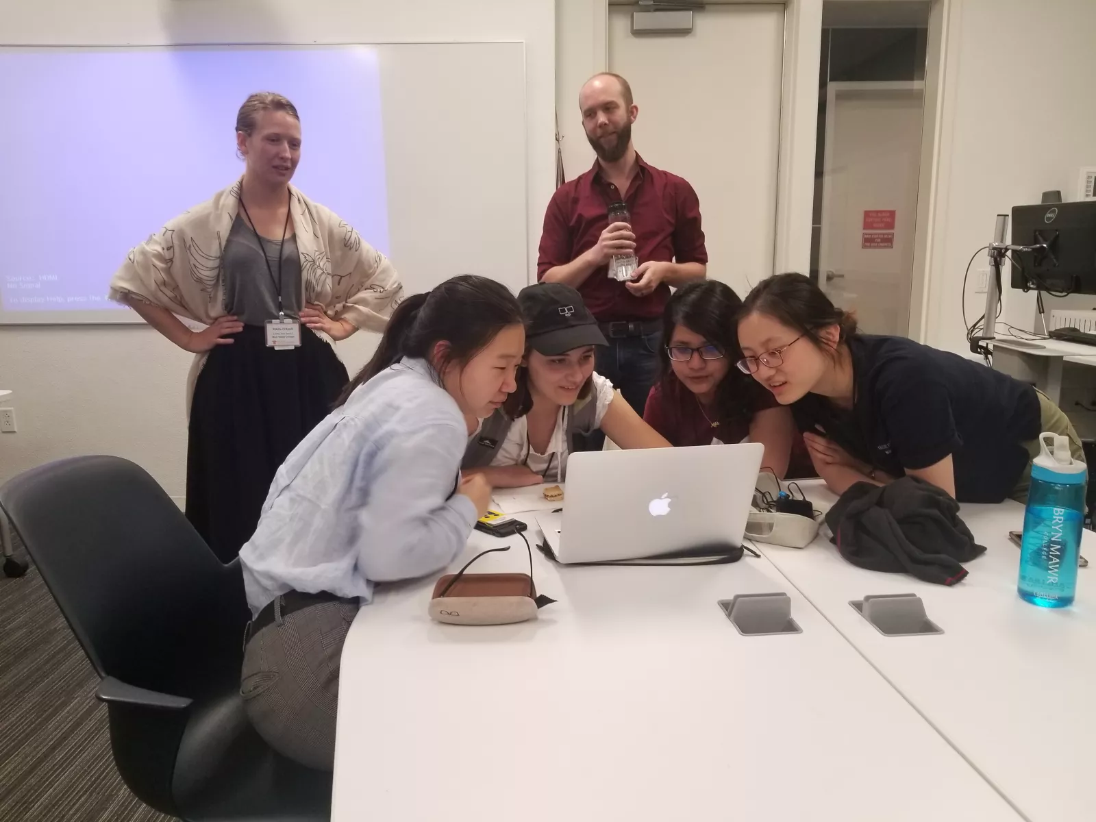 Digital Scholarship Summer Fellow gather around looking at a computer