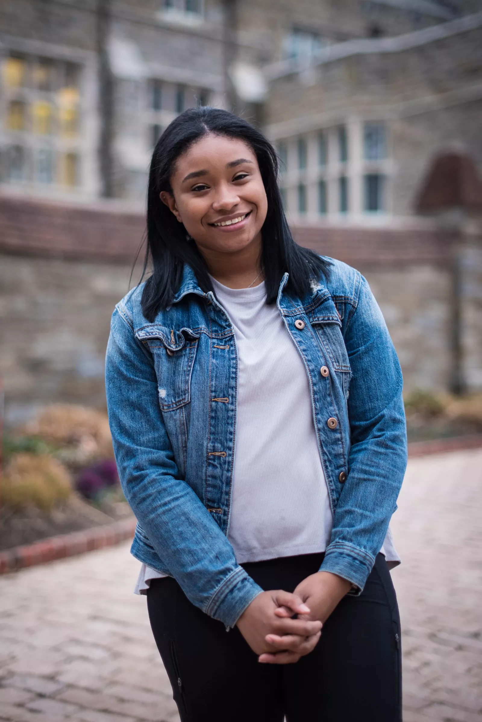 Alisha stands in front of stone building