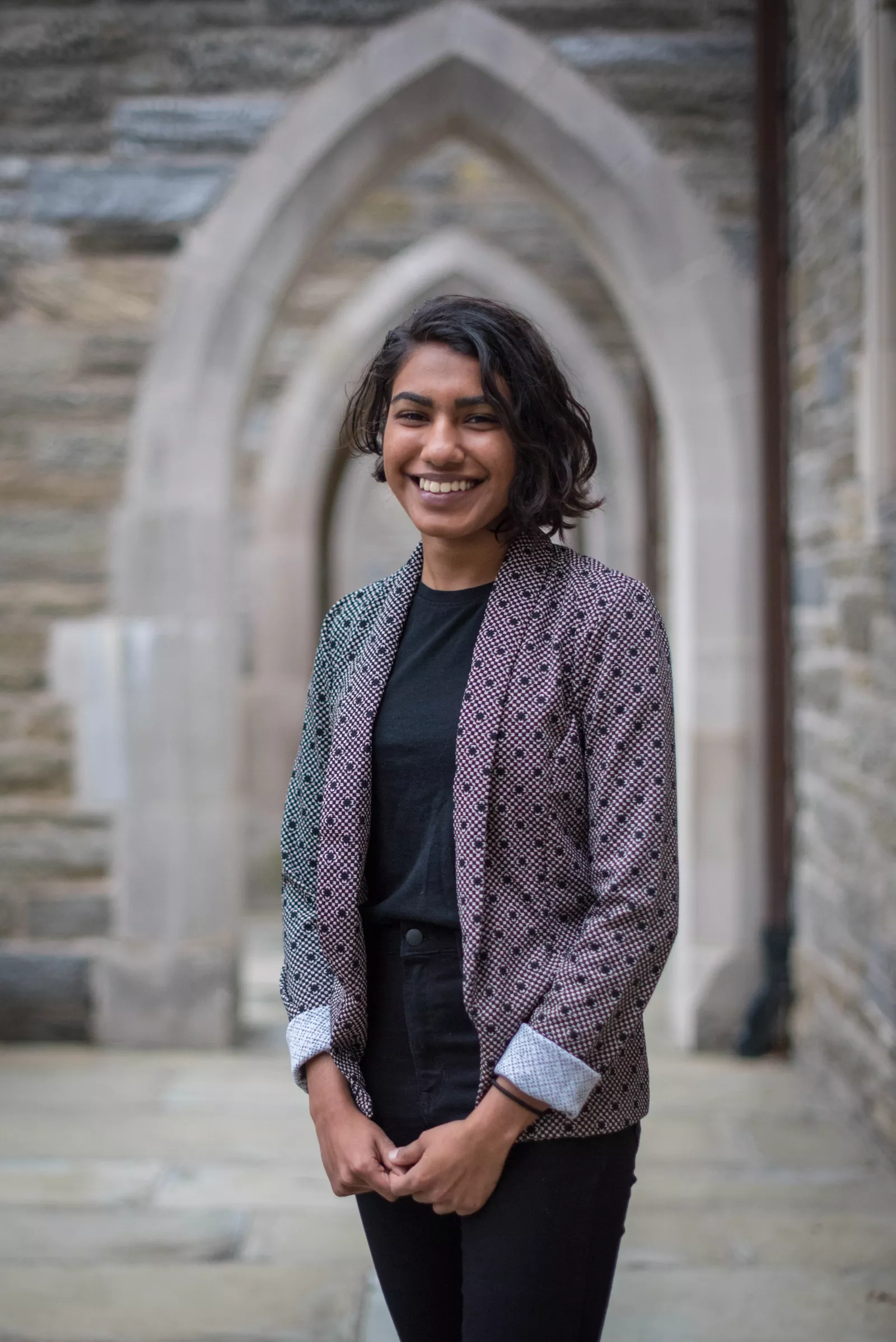 Nanda stands in front of stone arches